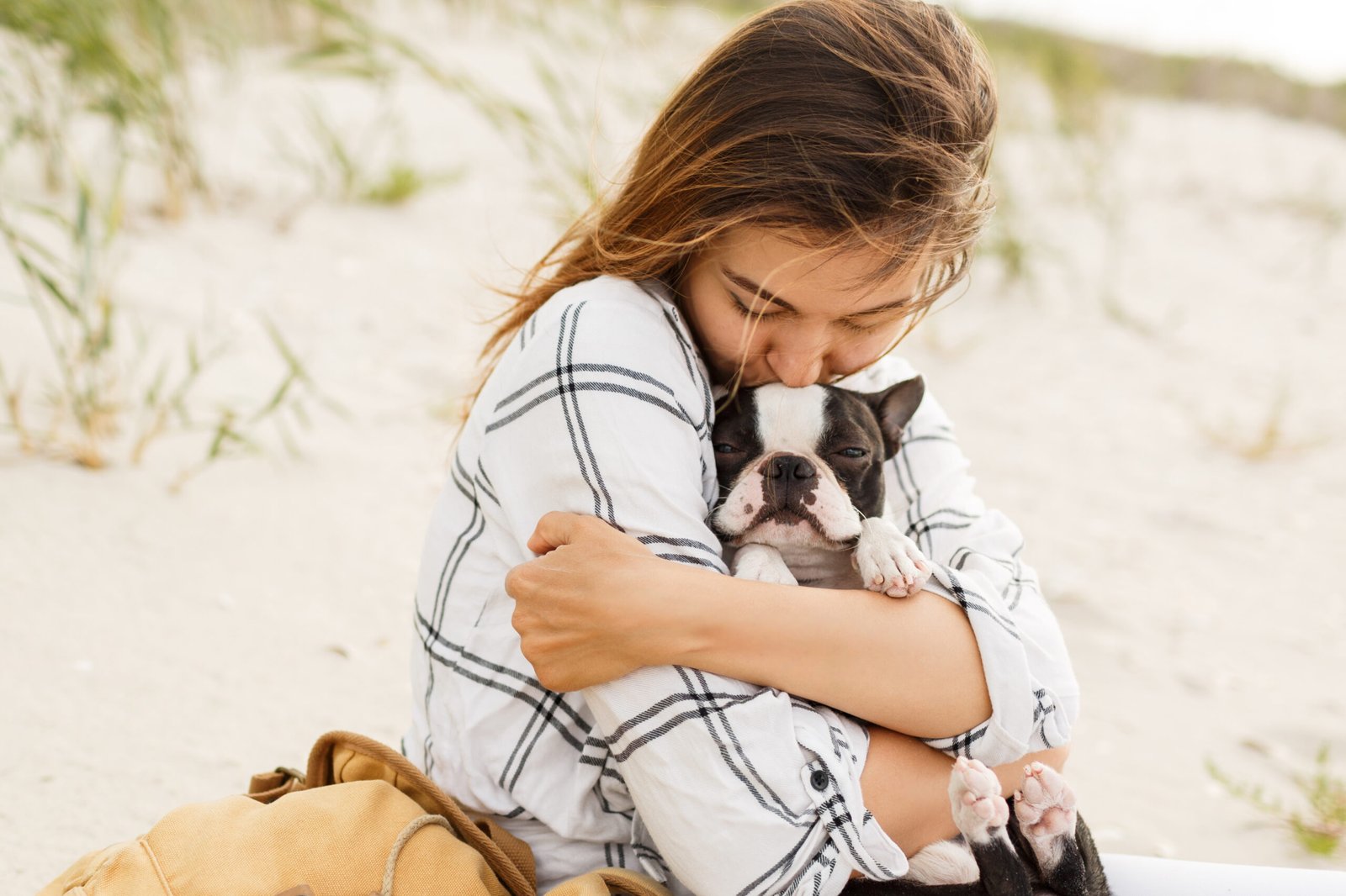 mujer abrazando su bulldog en la playa la luz del atardecer vacaciones de verano chica elegante con perro gracioso descansando abrazandose y divirtiendose momentos lindos
